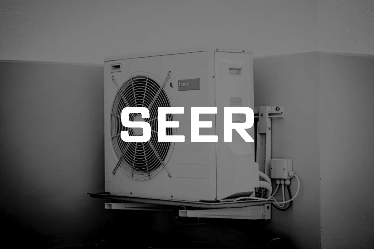 Zdjęcie przedstawia przymocowaną do elewacji pompę ciepła, z napisem SEER